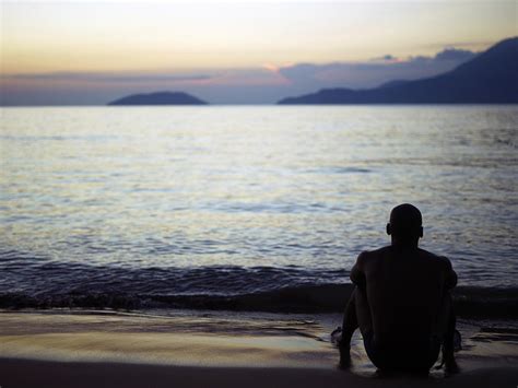 Man Sitting Alone On A Beach by Win-initiative/neleman