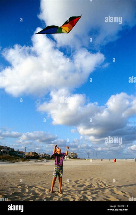 Young boy flying a kite on the beach Stock Photo - Alamy