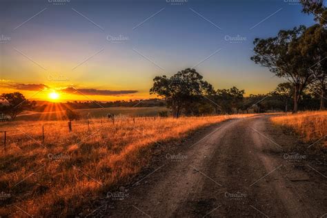 Countryside landscape with rural dirt road at sunset in Australia ...