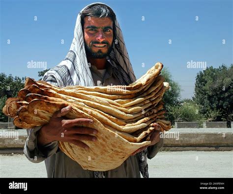 Kabul / Afghanistan: Man carrying many very large pieces of flat bread ...