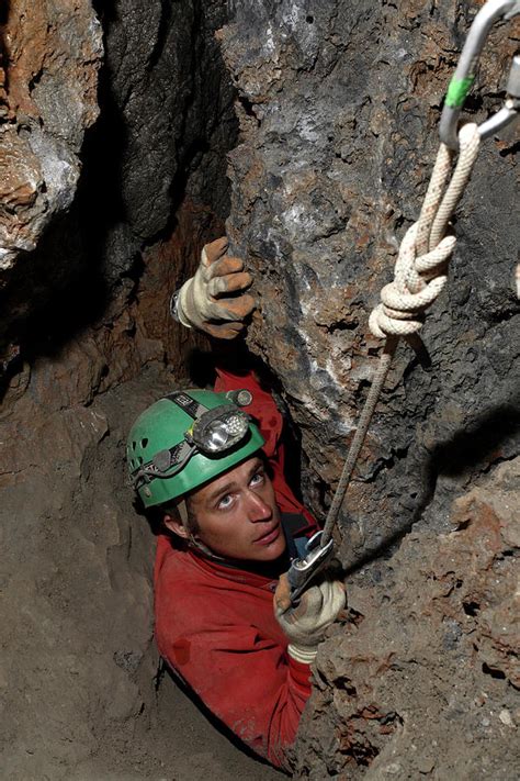 Cave Explorer Forces His Way Photograph by Robbie Shone