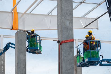 Construction worker working at boom lift installation steel roof beam ...