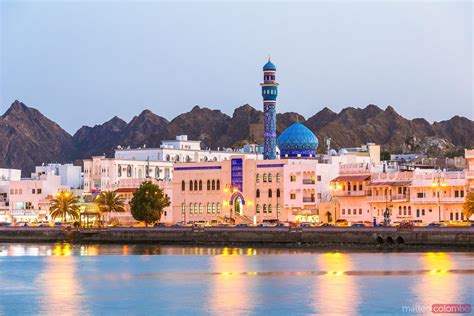 - Oman, Muscat. Mutrah harbour and old town at dusk | Royalty Free Image