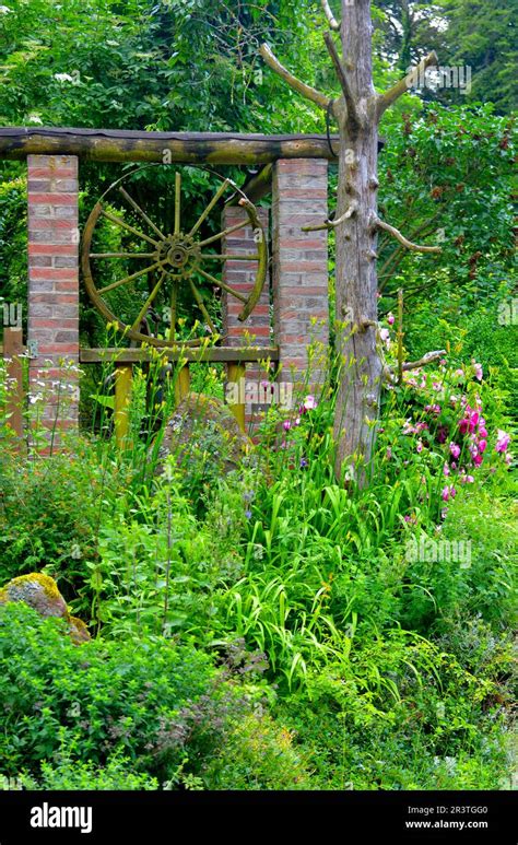 Nature garden old wagon wheel Stock Photo - Alamy