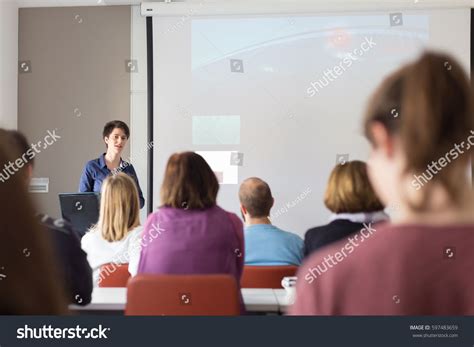 Female speaker giving presentation in lecture hall at university ...