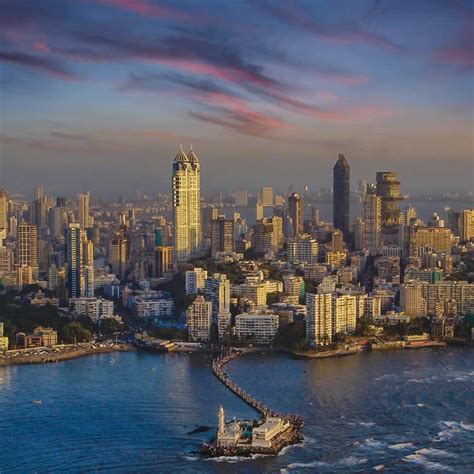 an aerial view of a large city and the ocean with boats in the foreground