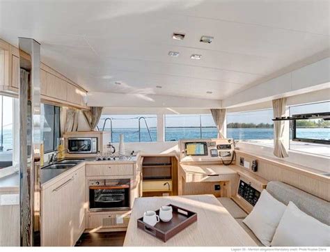 the interior of a sailboat with lots of wood furniture and windows ...