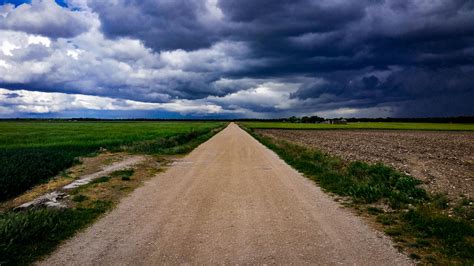 Dirt Road Surrounded With Green Field Under Cloudy Sky · Free Stock Photo