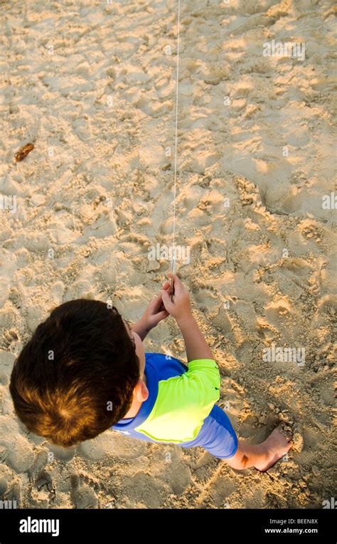 Young boy flying a kite on the beach Stock Photo - Alamy