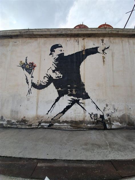 a painting on the side of a building with a man holding flowers