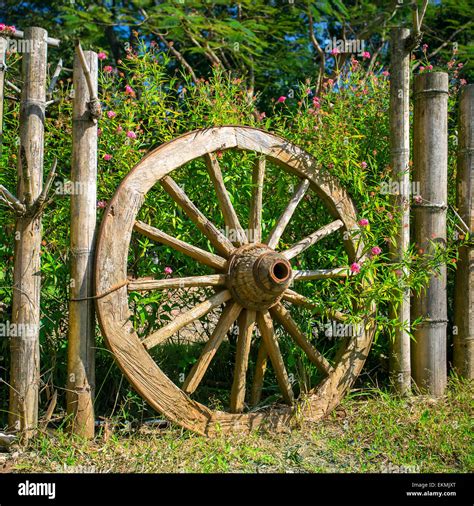 An old wagon wheel displayed as a garden decoration Stock Photo - Alamy