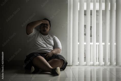 Lonely fat man crying near the window Stock Photo | Adobe Stock