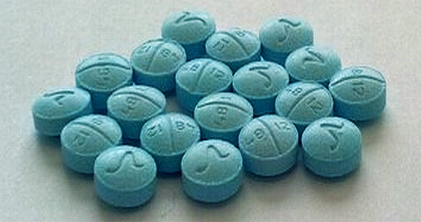 Qualitest Roxicodone (oxycodone hcl) 30mg barrel shaped pills with a curly V on one side and on the other side 48 12. They are scored and blue.