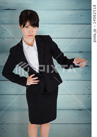 Composite image of focused businesswoman pointing 14062518