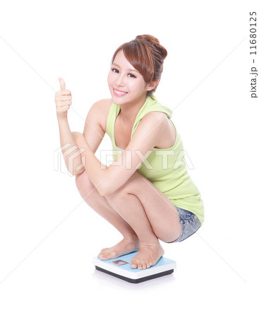 Happy slim woman with scales and show thumb up 11680125