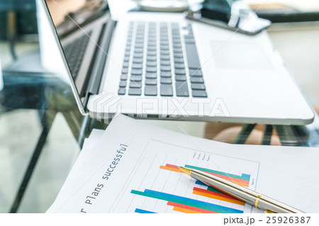 Financial charts on the table with laptop . 25926387