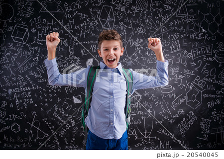 Excited and victorious boy against blackboard with 20540045