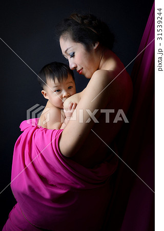 asian mother holding and breast feeding her baby 31539244