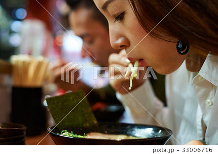 A portrait of a woman eating ramen 33006716