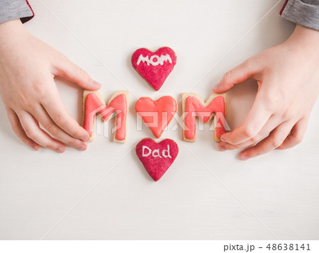 Hands of a younger daughter and word MOM 48638141