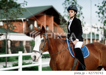 Rider elegant woman riding her horse outside 42770743