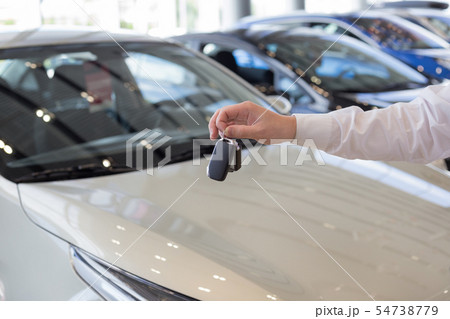 Dealer holding keys to a new car. 54738779