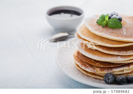 A stack of delicious pancakes with honey. 57989682