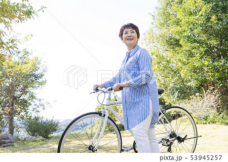 自転車を押して散歩するシニア女性 53945257