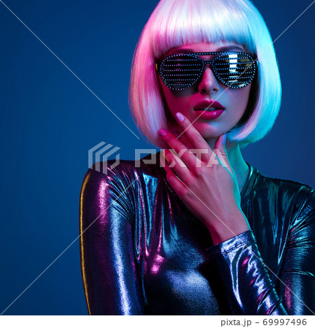 Stylish blonde in shiny dress and sunglasses with stresses. Closeup face  of beautiful  fashionable woman in white wig. Art portrait  of  an young attractive model. Fantasy style. Glamour fashion girl 69997496