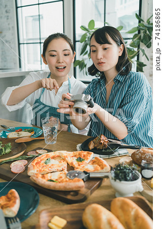 デジカメで食卓の料理写真を撮る女性 74186865