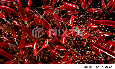 Freeze motion of flying chilli peppers on black background. 85153632