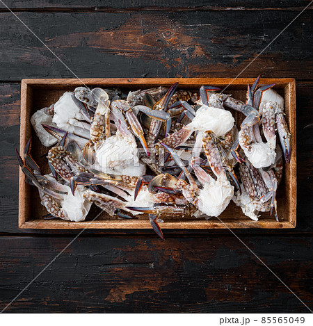 Frozen raw blue swimming crab meat, in wooden box, on dark wooden background 85565049