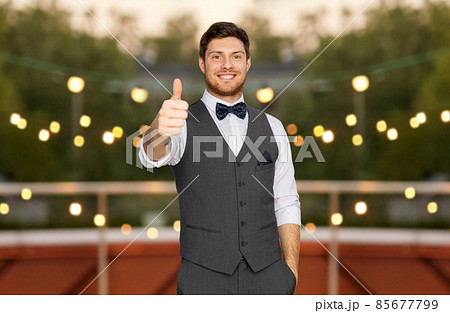 man in suit showing thumbs up at rooftop party 85677799