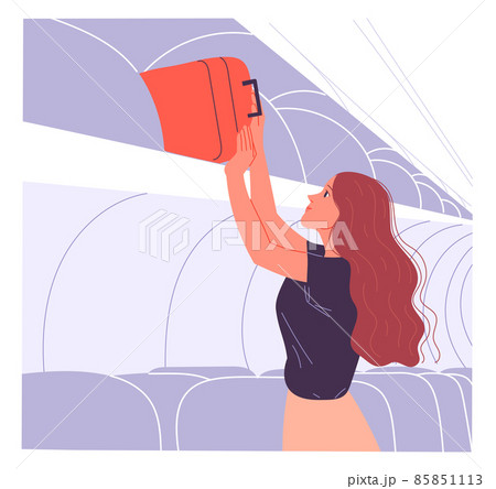 Woman passenger puts her hand baggage on the overhead shelf. 85851113