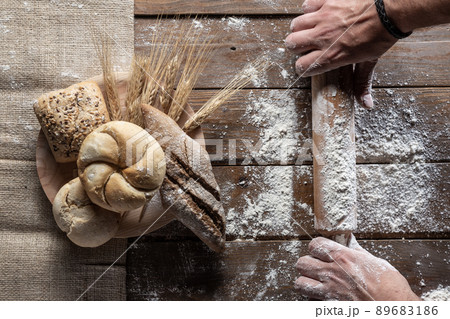 Bread with wheat ears and flour on wood board, top view 89683186