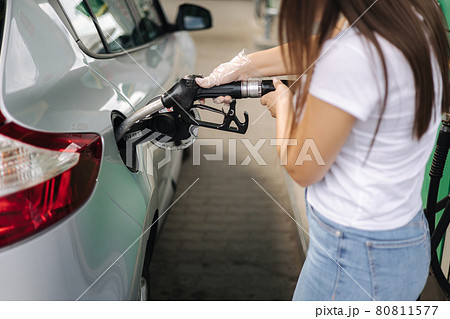 Attractive young woman refueling car at gas station. Female filling diesel at gasoline fuel in car using a fuel nozzle. Petrol concept. Side view 80811577