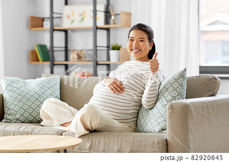 happy pregnant asian woman showing thumbs up 82920645