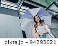 Beautiful Asian woman happiness holding umbrella and listening favourite music on headphones from mobile phone, Happiness relaxation summer in park with music 94293021