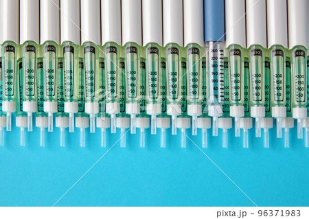 Diabetic insulin pens lined up on a blue background. Provision o 96371983