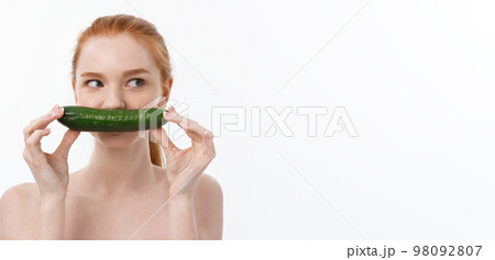 Cheerful happy beautiful girl with cucumber on her hand - isolated on white 98092807