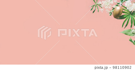 Golden Easter eggs in assorted floral and jungle tree green leaves and white flowers corner border on peach pink. Natural sustainable environment friendly cosmetics mockup flat lay banner 98110902