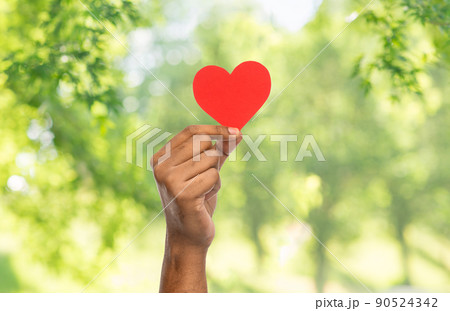 hand holding red heart over natural background 90524342