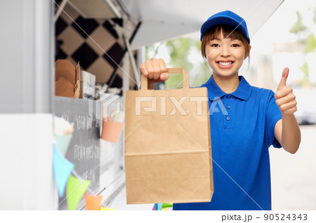 delivery woman with paper bag showing thumbs up 90524343