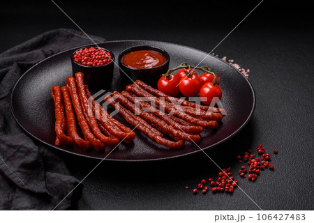 Delicious thin smoked hunting sausages with salt, spices and herbs 106427483