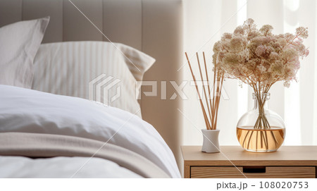 Reed diffuser on nightstand near bed in room. 108020753