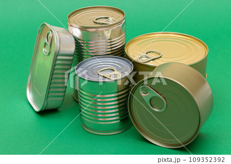 Unopened Tin Cans with Blank Edges on Green Background 109352392