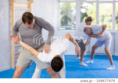 Self defense training for adults - men learn how to do power grabs 109677970