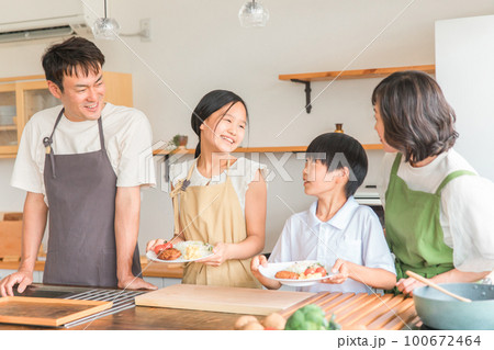 家のキッチンで子供と一緒に料理・クッキング・お手伝いする子供と夫婦・親子・家族 100672464