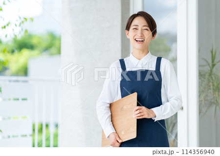 カフェの店内に案内する女性 114356940