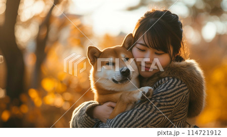 公園で犬を抱きしめる日本人女性 114721912